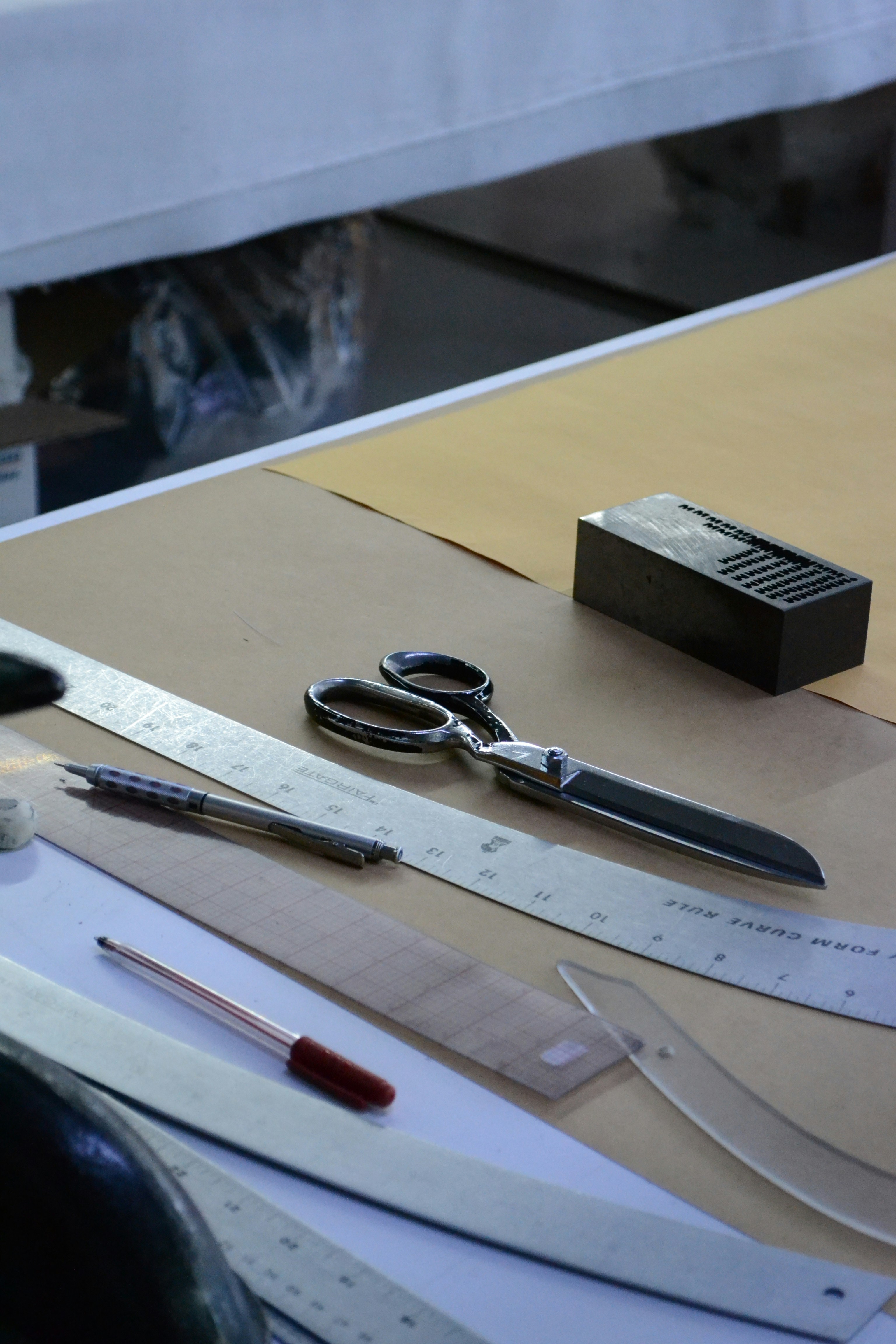 Tailor's scissors, ruler and pencil on a cutting workbench